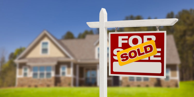 a sold sign on a house that was recently bought by a married couple