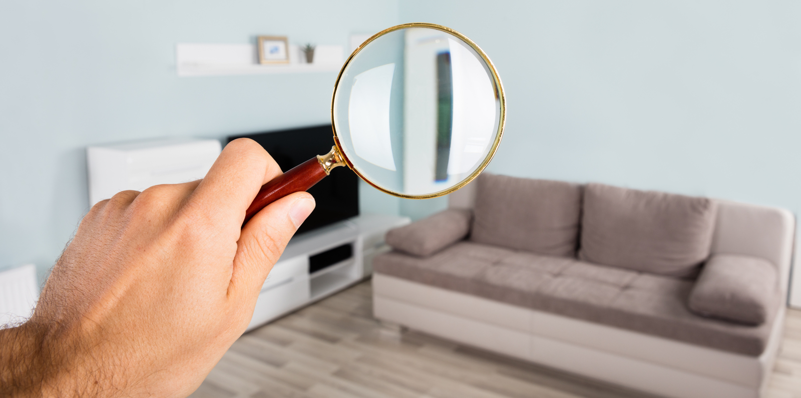 person holding a magnifying glass to inspect a home