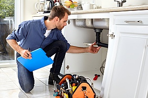 a plumbing contractor that is inspecting the pipes and drains in a home