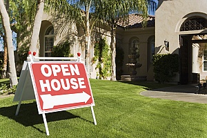 an open house sign in front of a staged luxury home