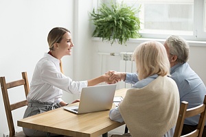 Real estate agent shaking hands with couple