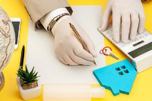 A real estate listing agent working at his desk wearing gloves during COVID-19 pandemic