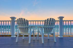 Beach chairs facing sunset 