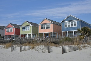 four colorful beach rental properties shown before a sandy beach