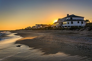 large white beach vacation home shown at sunset that would be good for investing purposes